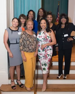 Group of diverse women, possibly c stem donor event attendees, pose on stairs.