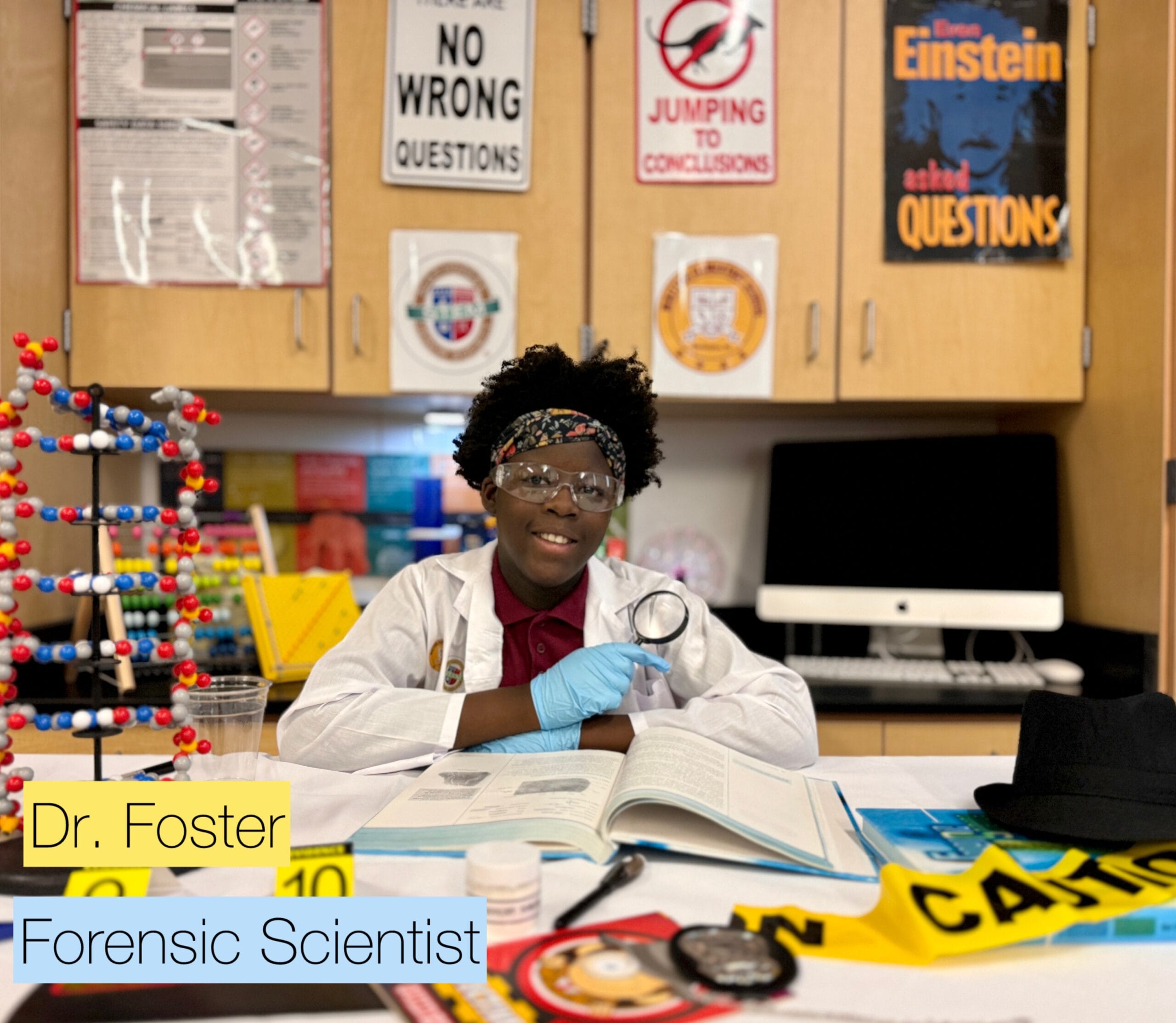 Young forensic scientist, part of a C-STEM program, examines evidence with a magnifying glass. "No Wrong Questions" text visible.