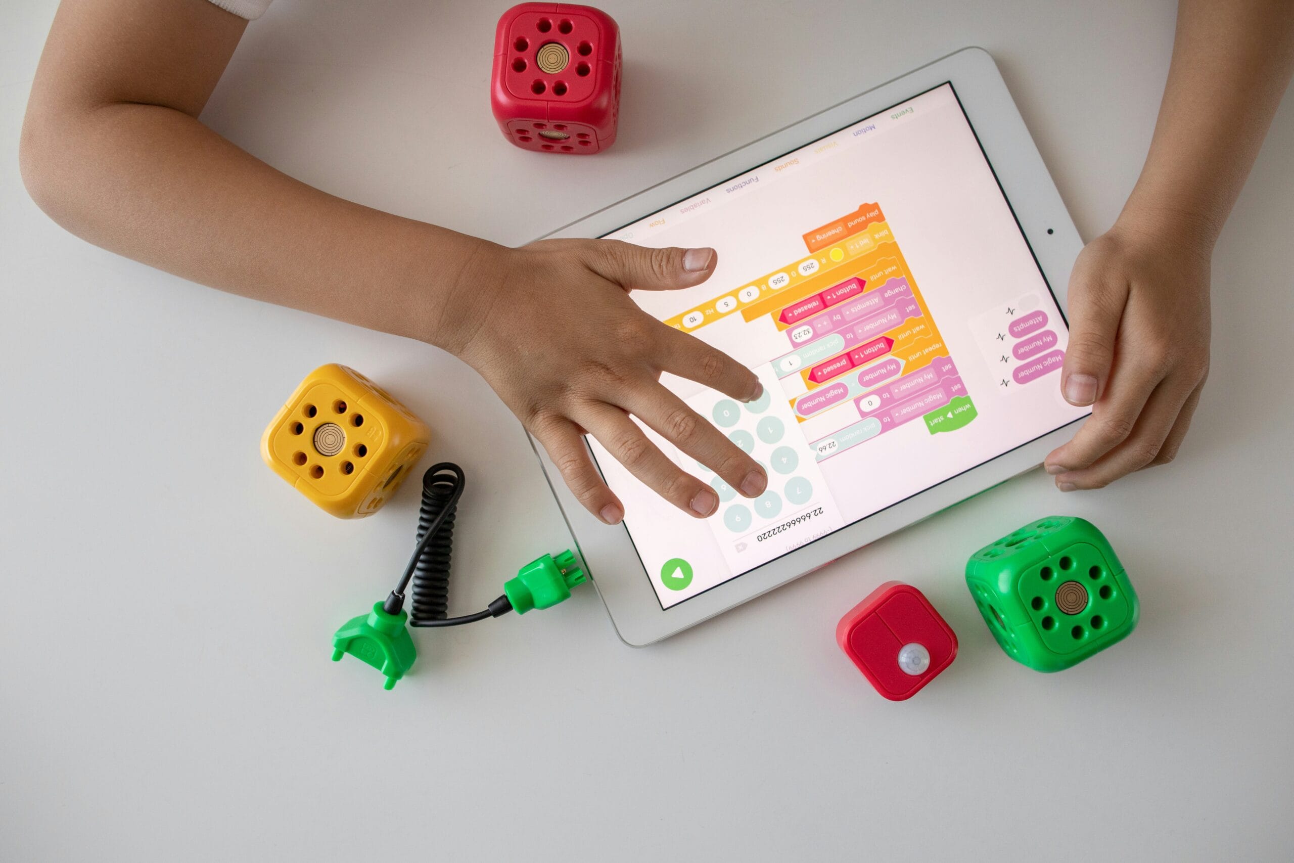 Child using a tablet to code with C-STEM educational blocks.